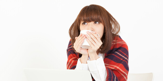 毛布で暖をとる女性