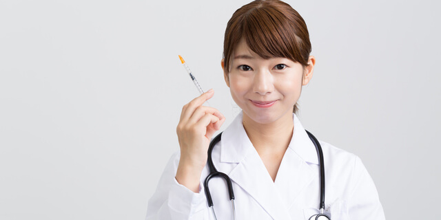 注射を持つ女性