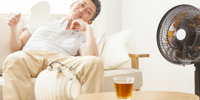 扇風機に当たる男性