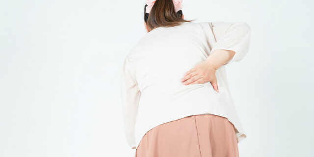右腰を押さえる女性