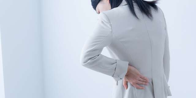 腰をおさえる女性