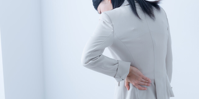 腰をおさえる女性