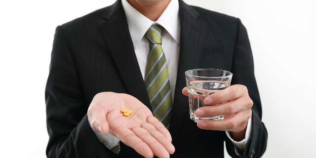 薬を飲む男性
