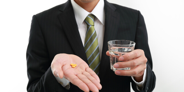 薬を飲む男性