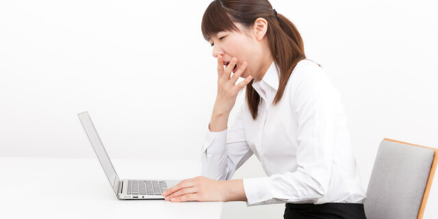 仕事中にあくびをする女性