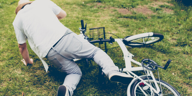自転車から倒れる男性
