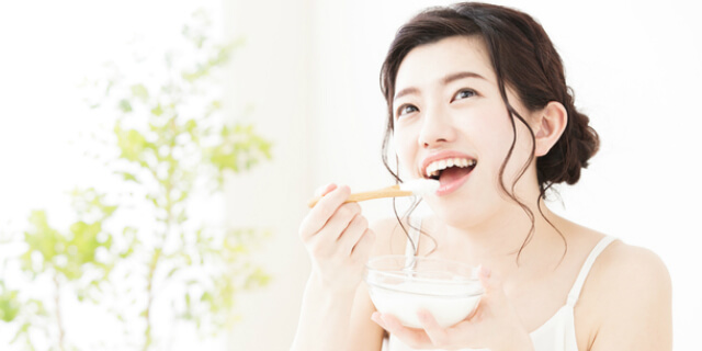 ヨーグルトを食べる女性
