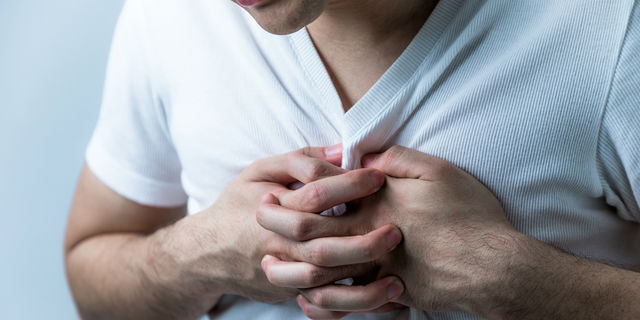 心臓を押さえる男性