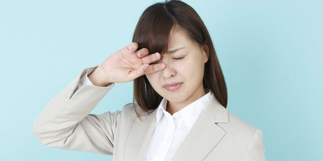 目をかく女性