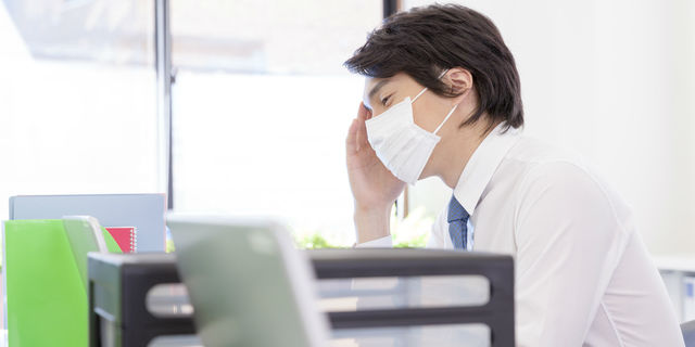 風邪で仕事する男性
