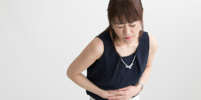 胃酸過多から発展する病気に悩む女性