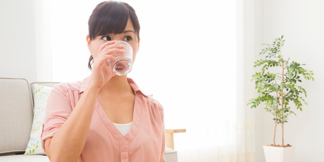 薬を飲む女性