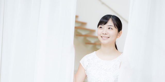 カーテンを閉める女性
